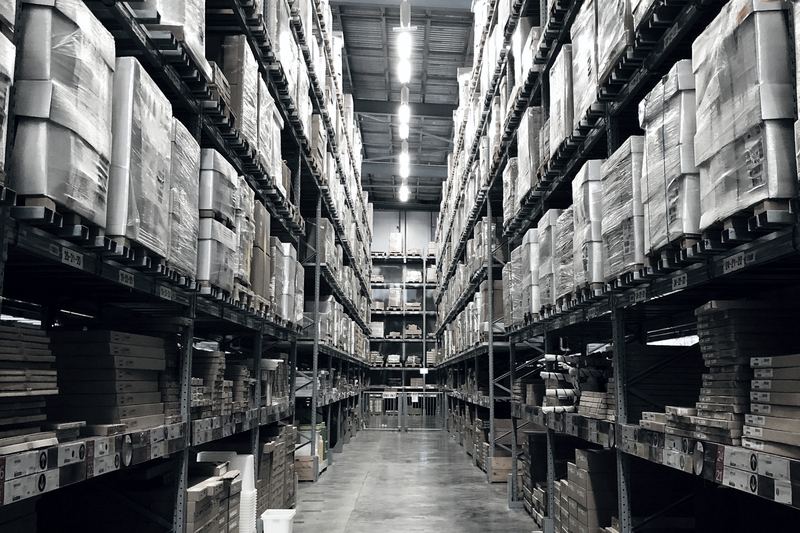 Racked pallets of goods stretching down a warehouse aisle